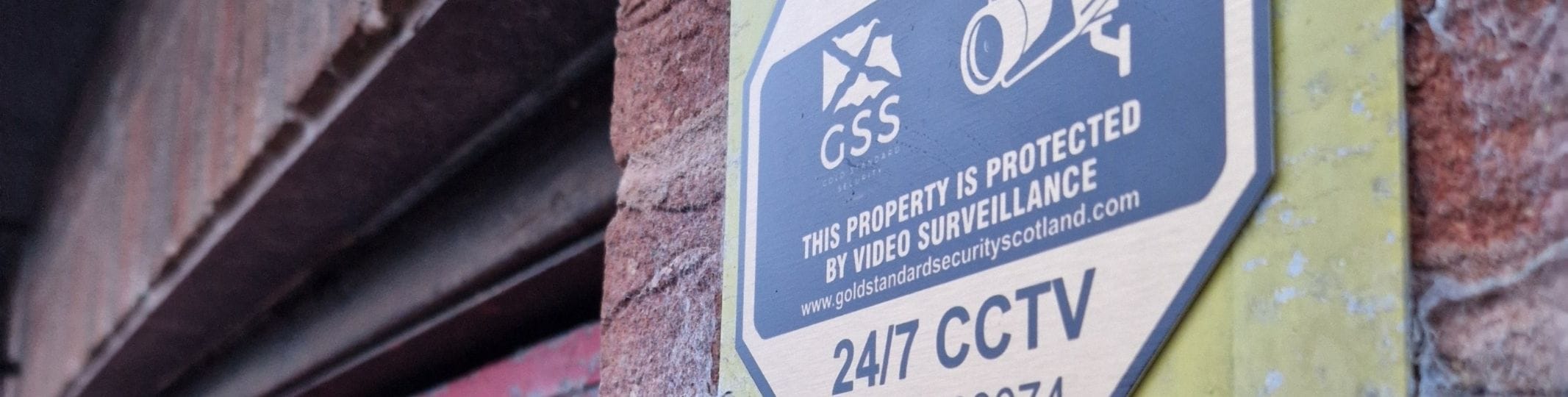 sign that informs people that the property has 24/7 CCTV surveillance